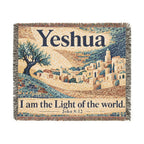 A square woven tapestry with fringe edges, featuring a mosaic-style depiction of a hillside town under a pale sky, with the word 'Yeshua' at the top and the phrase 'I am the Light of the world. John 8:12' at the bottom.