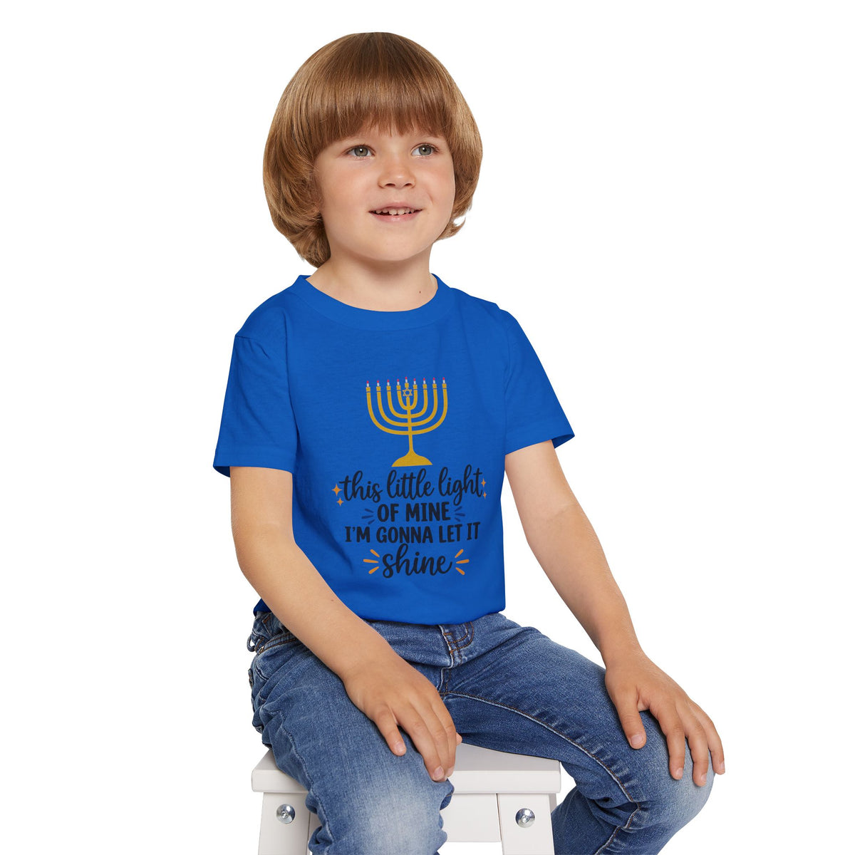 Child wearing a blue t-shirt with a graphic design on a white background
