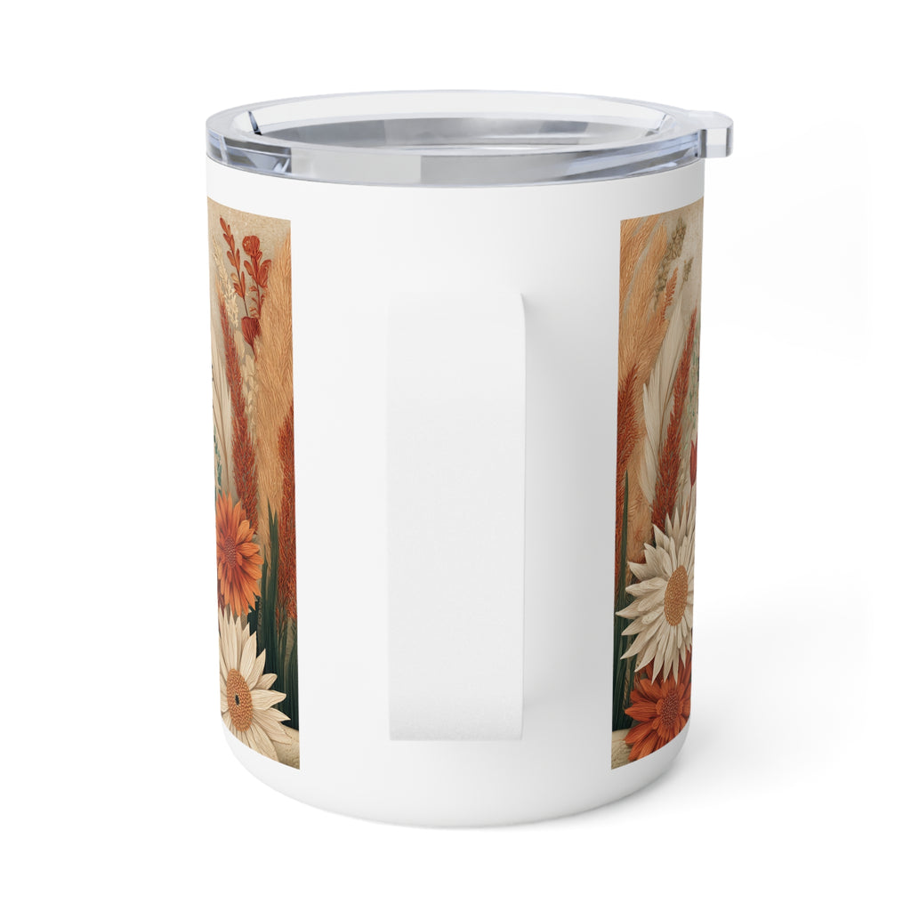 A white insulated tumbler with a clear lid and a vertical handle, featuring a printed autumn floral and grass pattern on the sides, shown on a white background.