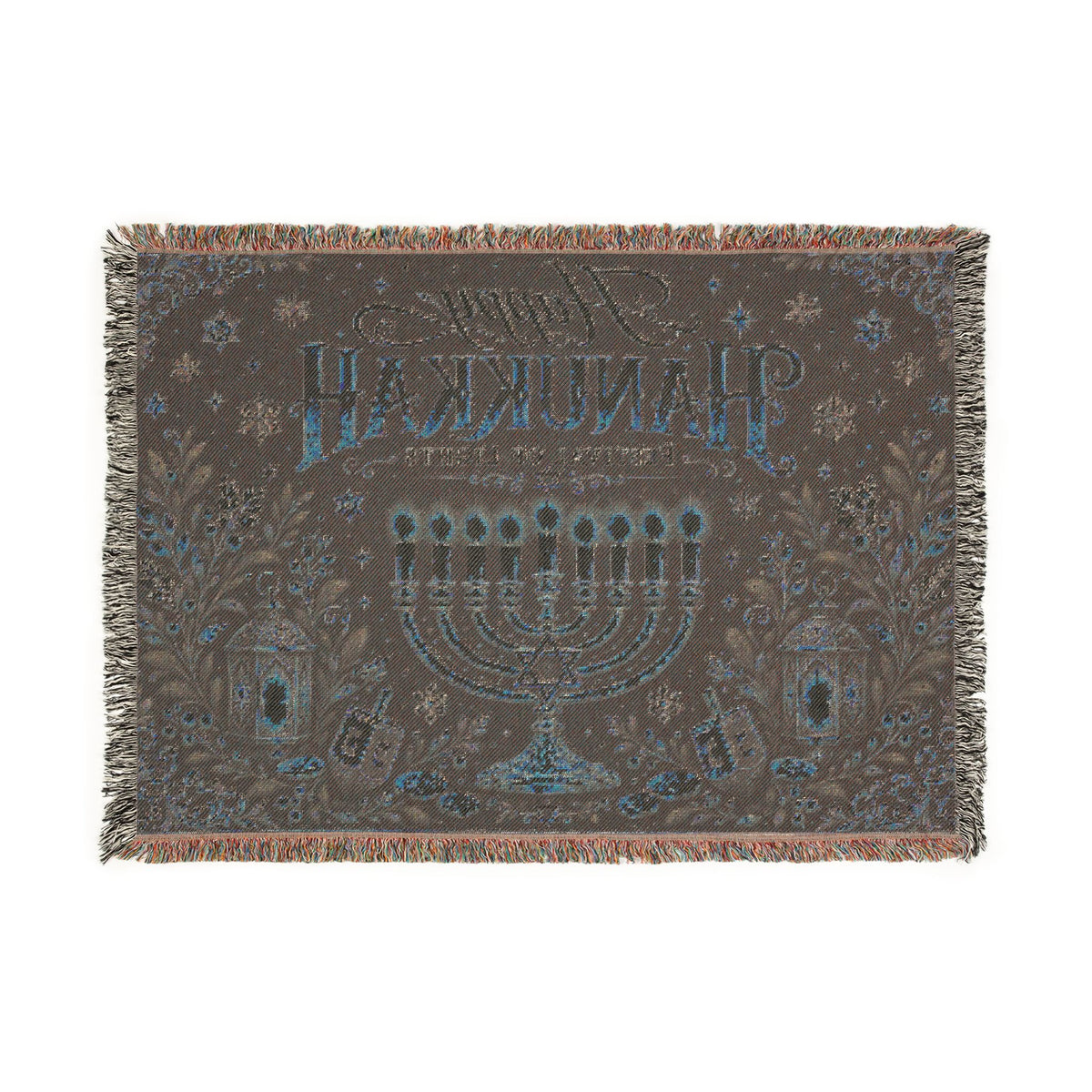 A rectangular woven throw blanket with fringe on all sides, featuring a dark brown background with a blue and beige menorah, stars, floral motifs, and Hebrew text reading 'Shin L'Chaim' on a white background.