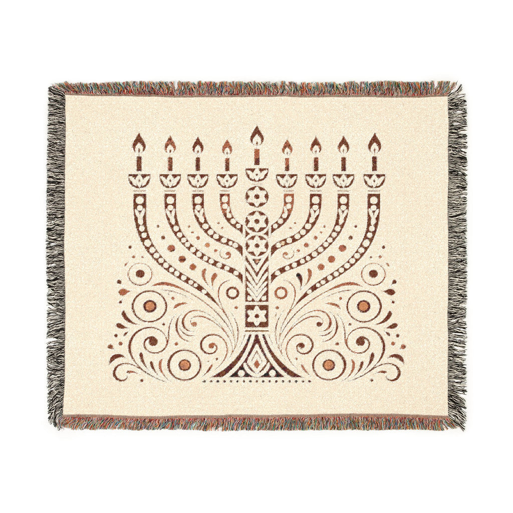 A square woven throw blanket with fringed edges, featuring a brown menorah and ornamental scroll pattern on a warm cream background.