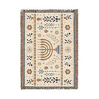 A rectangular woven rug with a cream background and multicolor traditional patterns, featuring a central menorah motif and fringed edges, shown flat against a white background.