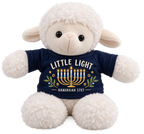 A plush white sheep toy wearing a navy blue shirt with a Hanukkah graphic that reads 'LITTLE LIGHT' and 'HANUKKAH 5787' with a gold menorah and blue candles.