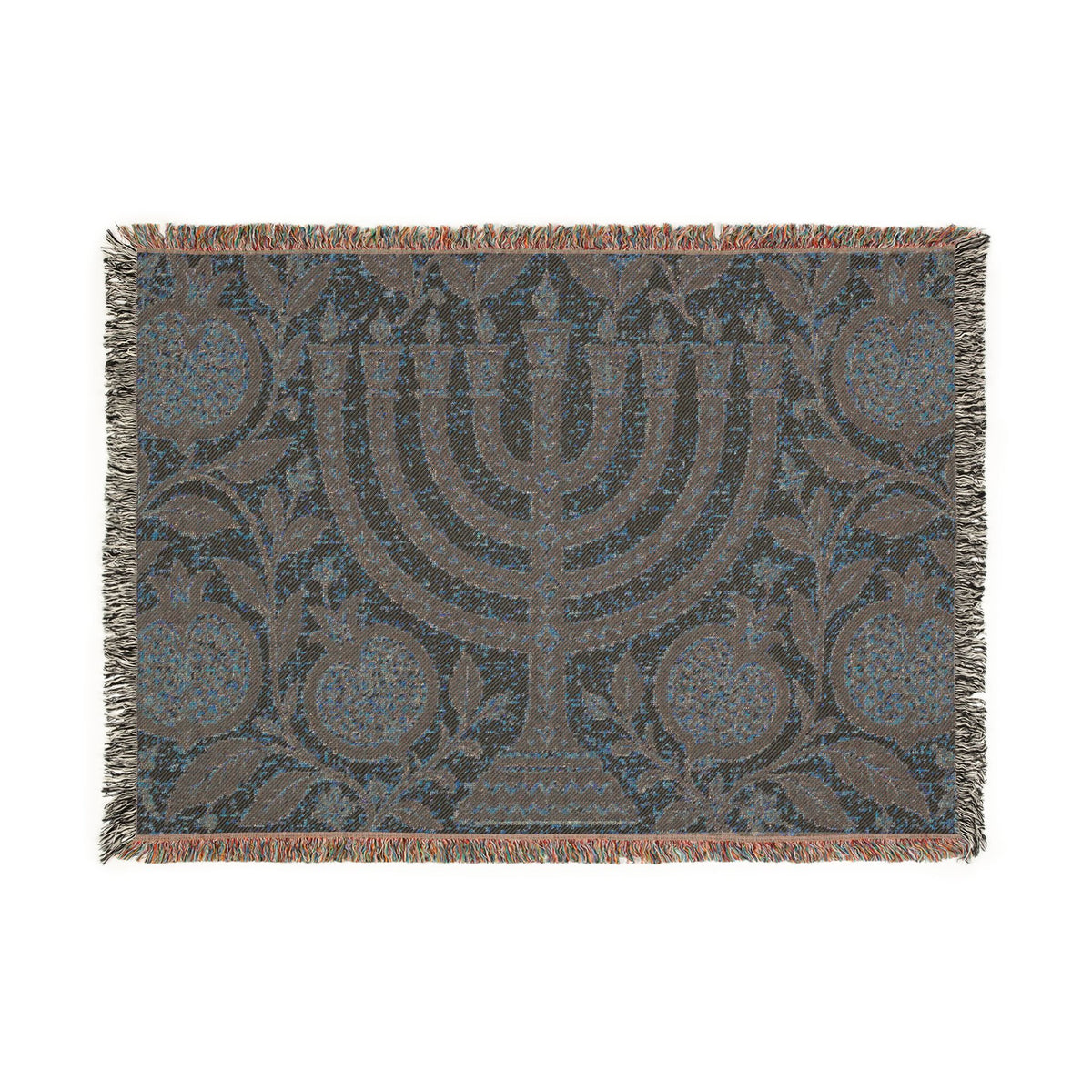 A rectangular woven throw blanket featuring a central menorah motif with pomegranate and floral patterns, finished with fringed edges in a muted blue, gray, and brown palette.