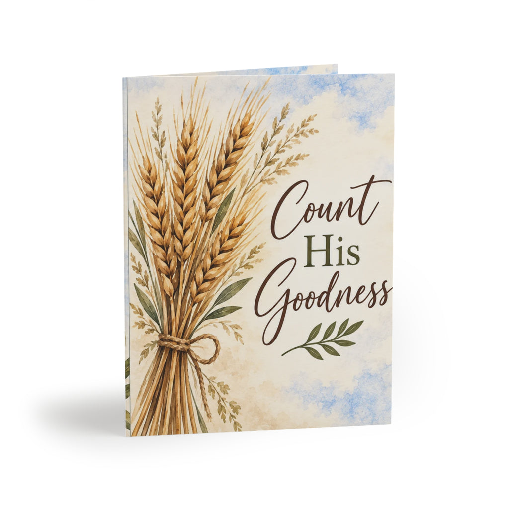 A greeting card featuring an illustration of a tied bundle of golden wheat stalks on a cream watercolor background with blue sky accents. The text 'Count His Goodness' is printed on the front.