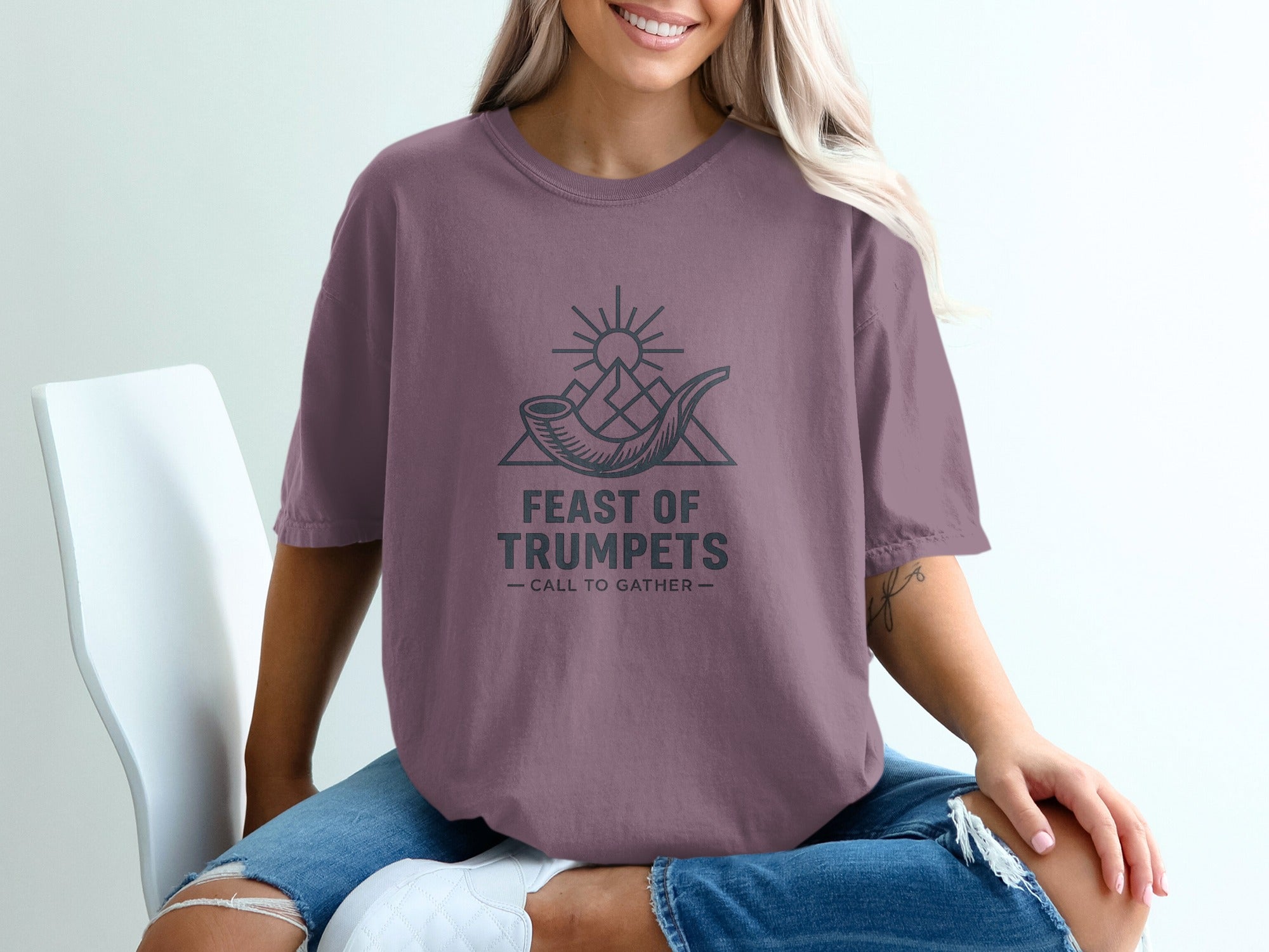 T-shirt graphic with text "FEAST OF TRUMPETS - CALL TO GATHER" and imagery of a shofar and mountains.