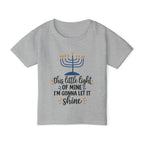 A heather gray short-sleeve t-shirt with a Hanukkah graphic on the front. The graphic features a blue menorah with orange flames and the text 'this little light OF MINE I'M GONNA LET IT shine' in black and orange lettering.