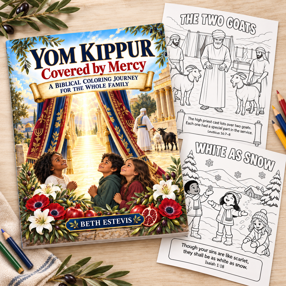 A children's coloring book and two coloring pages arranged on a table with colored pencils and olive branches. The book cover reads 'Yom Kippur Covered by Mercy' and shows an illustrated temple scene with children in front of a red tent.