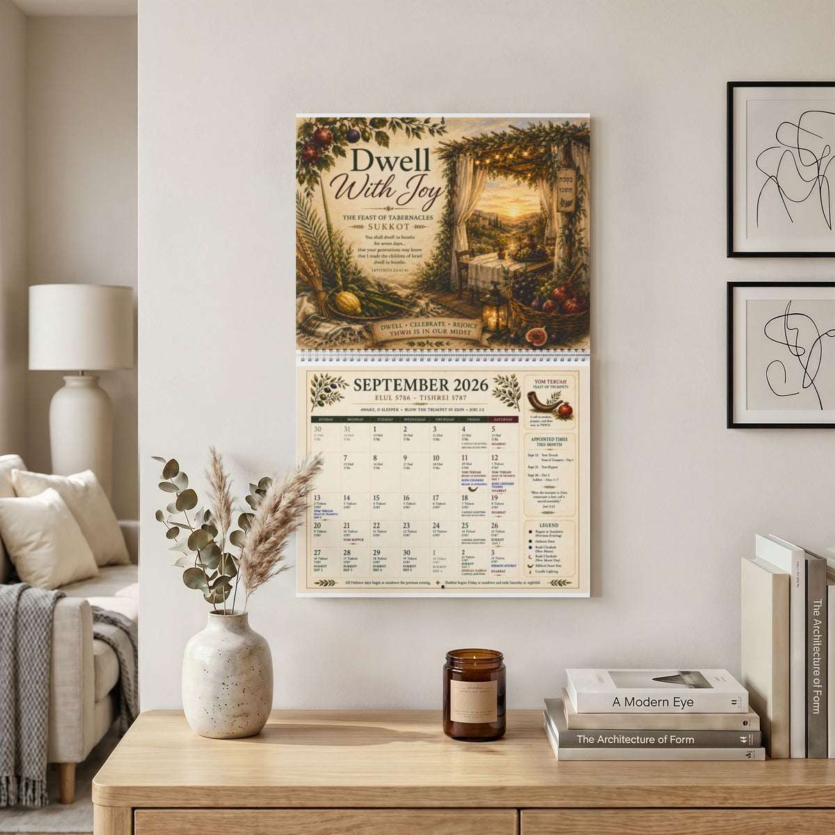 Appointed Times calendar open to September 2026 hanging on a wall above a wooden console with a vase