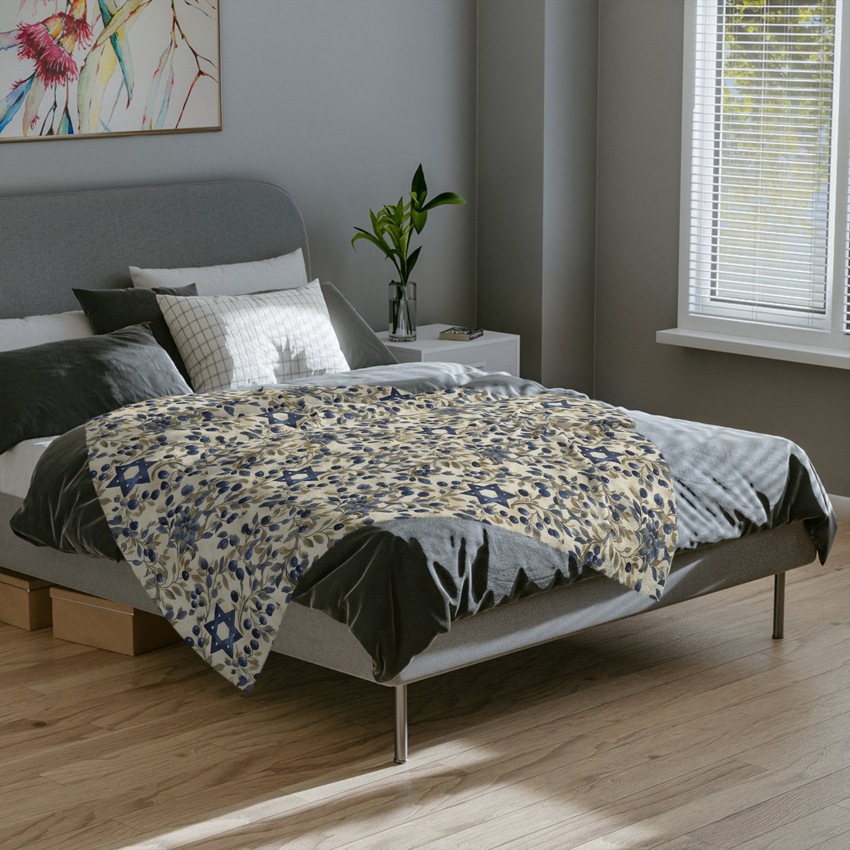 Cream and blue Star of David botanical blanket spread across a gray bed