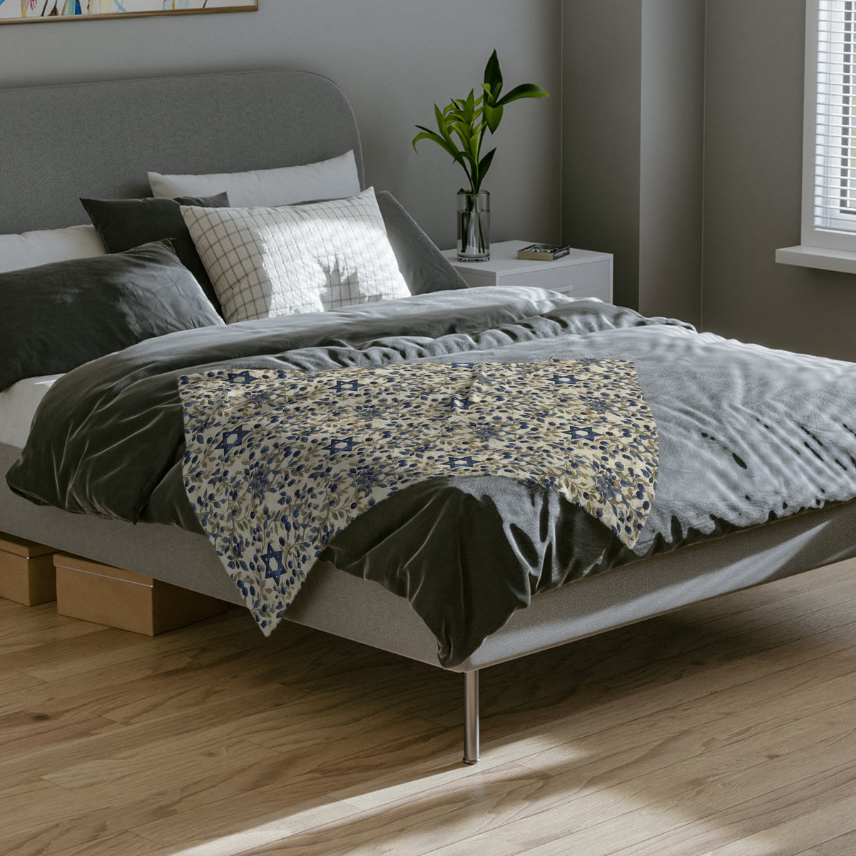 Cream Blue Star of David botanical blanket laid across the foot of a gray bed