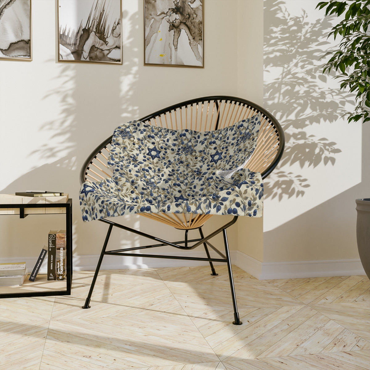 Blue Star of David botanical blanket folded on the seat of a round black chair