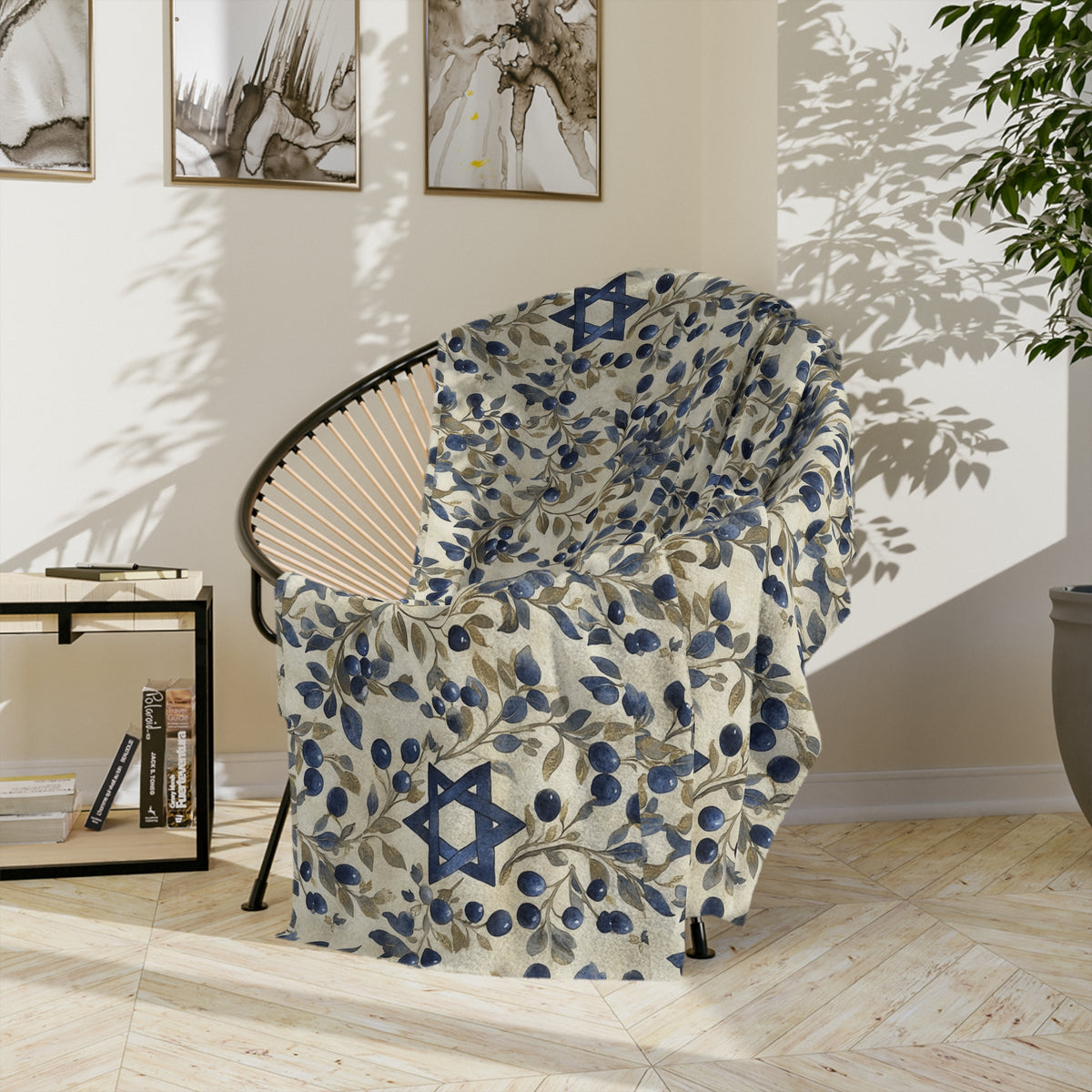 Cream Blue Star of David botanical blanket draped over a round black chair in a sunlit room
