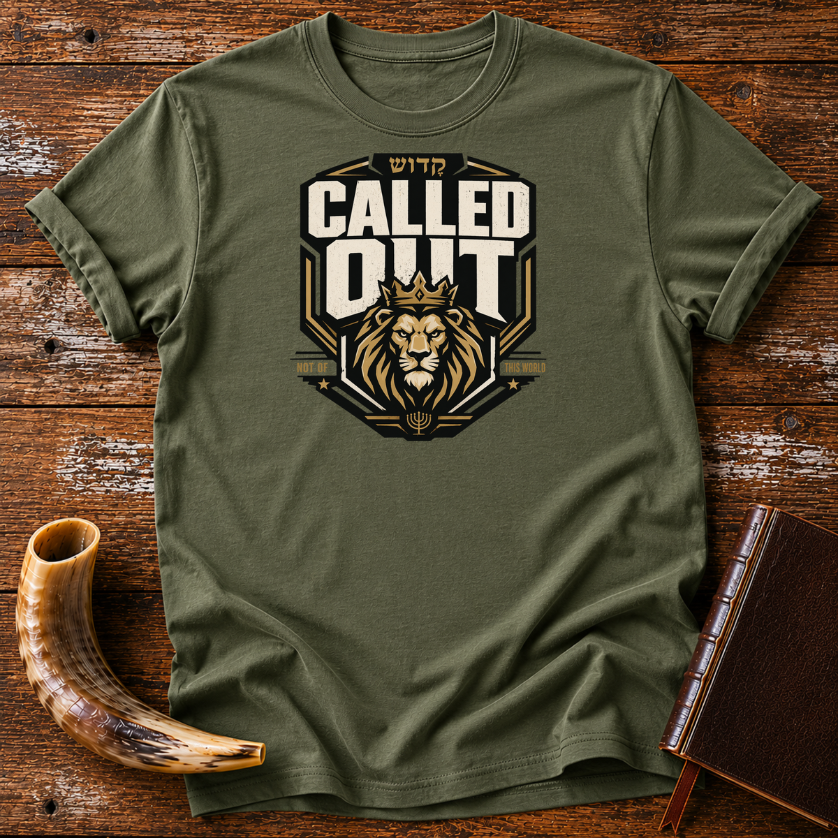 Military green Called Out tee with a crowned lion badge and Hebrew lettering, laid flat with a shofar and a leather-bound book