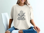 Feast of Trumpets logo with shofar, mountains, and sun on cream t-shirt.