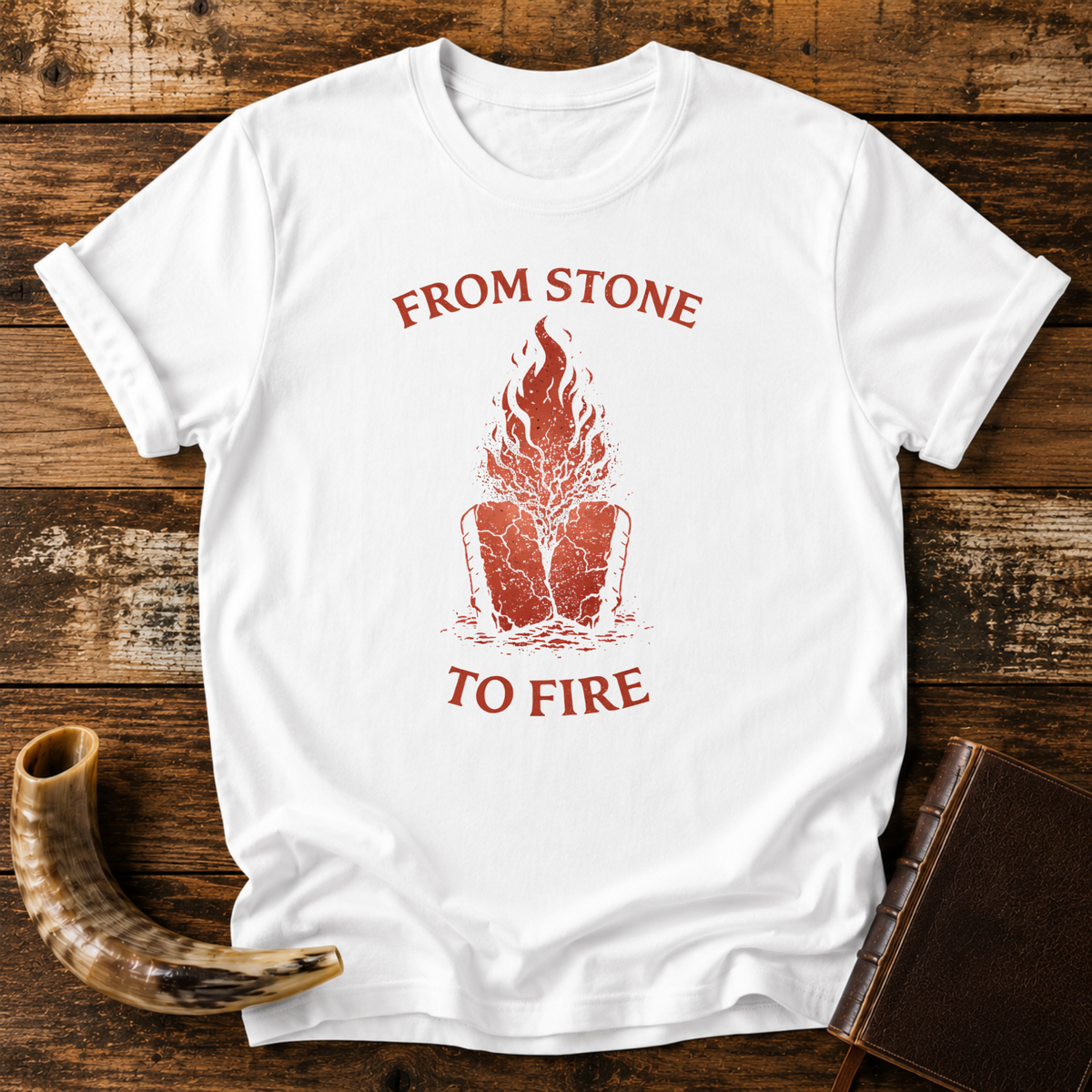 White From Stone to Fire tee with red flames rising from stone tablets, laid flat with a shofar and a leather-bound book