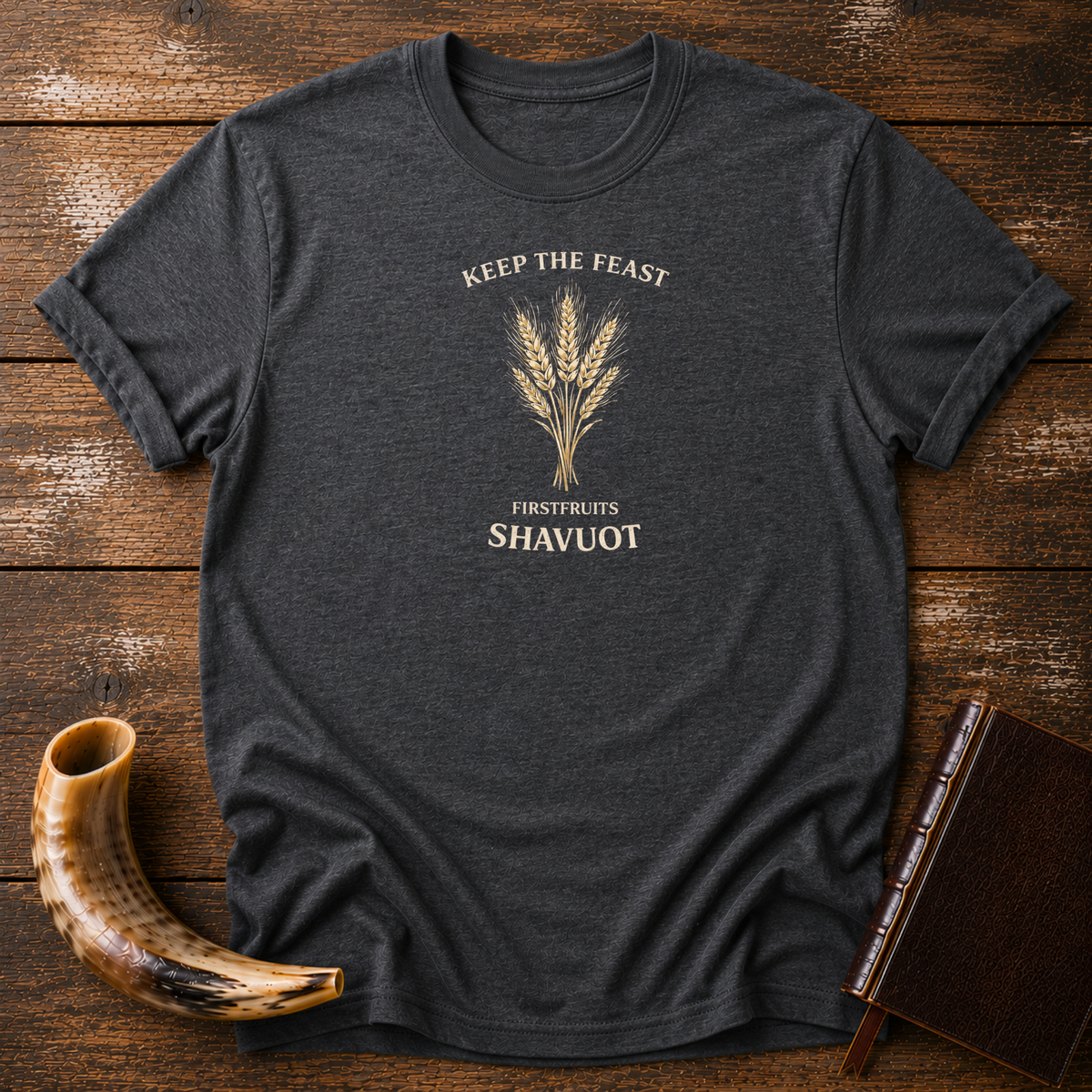 Dark heather Keep the Feast Firstfruits Shavuot tee with a cream wheat sheaf, laid flat with a shofar and a leather-bound book