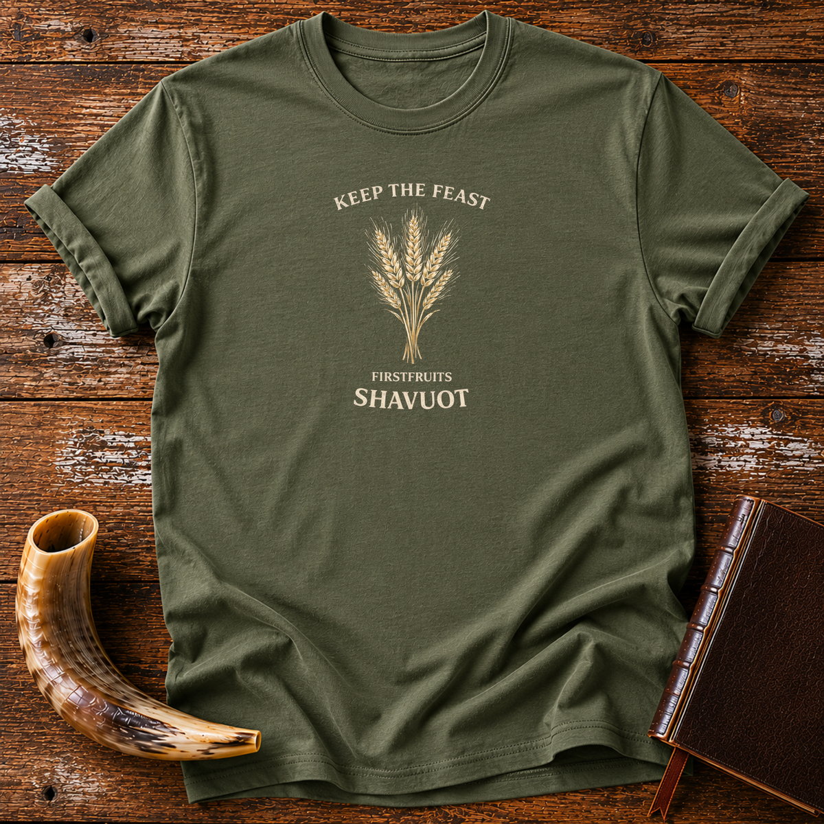 Military green Keep the Feast Firstfruits Shavuot tee with a cream wheat sheaf, laid flat with a shofar and a leather-bound book