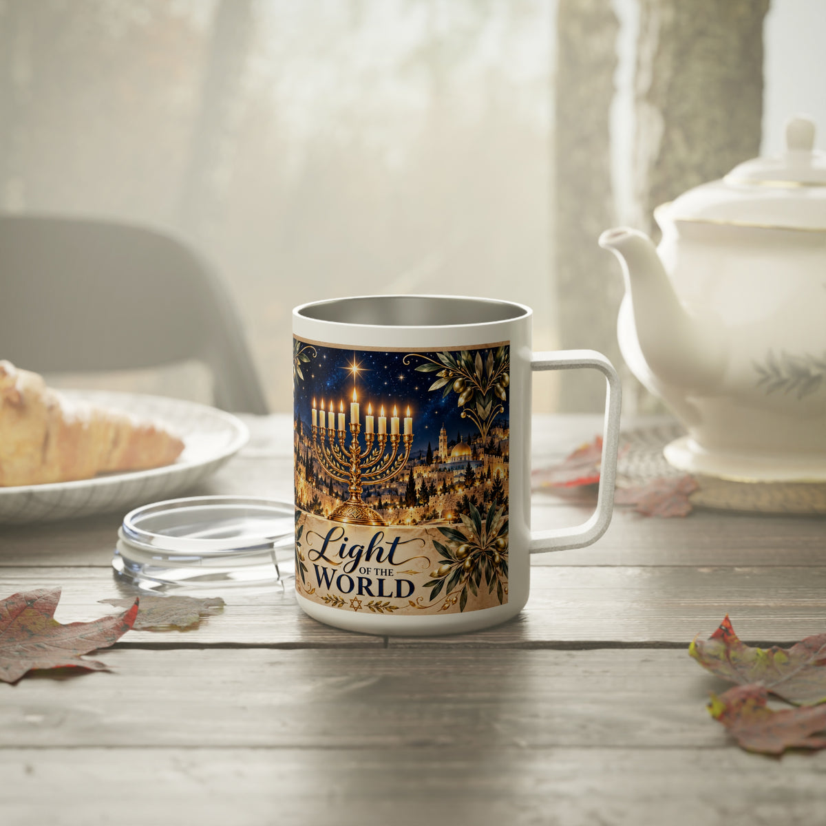 Light of the World Hanukkah insulated mug with lid off on a misty breakfast table with a teapot