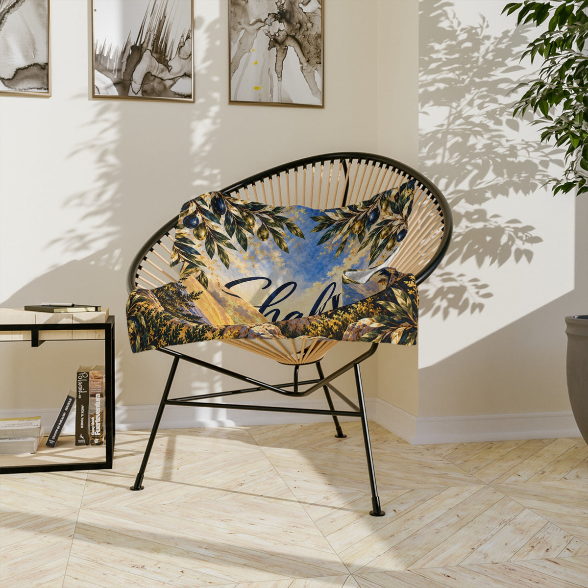Shalom Jerusalem blanket folded on the seat of a round black chair in a sunlit room