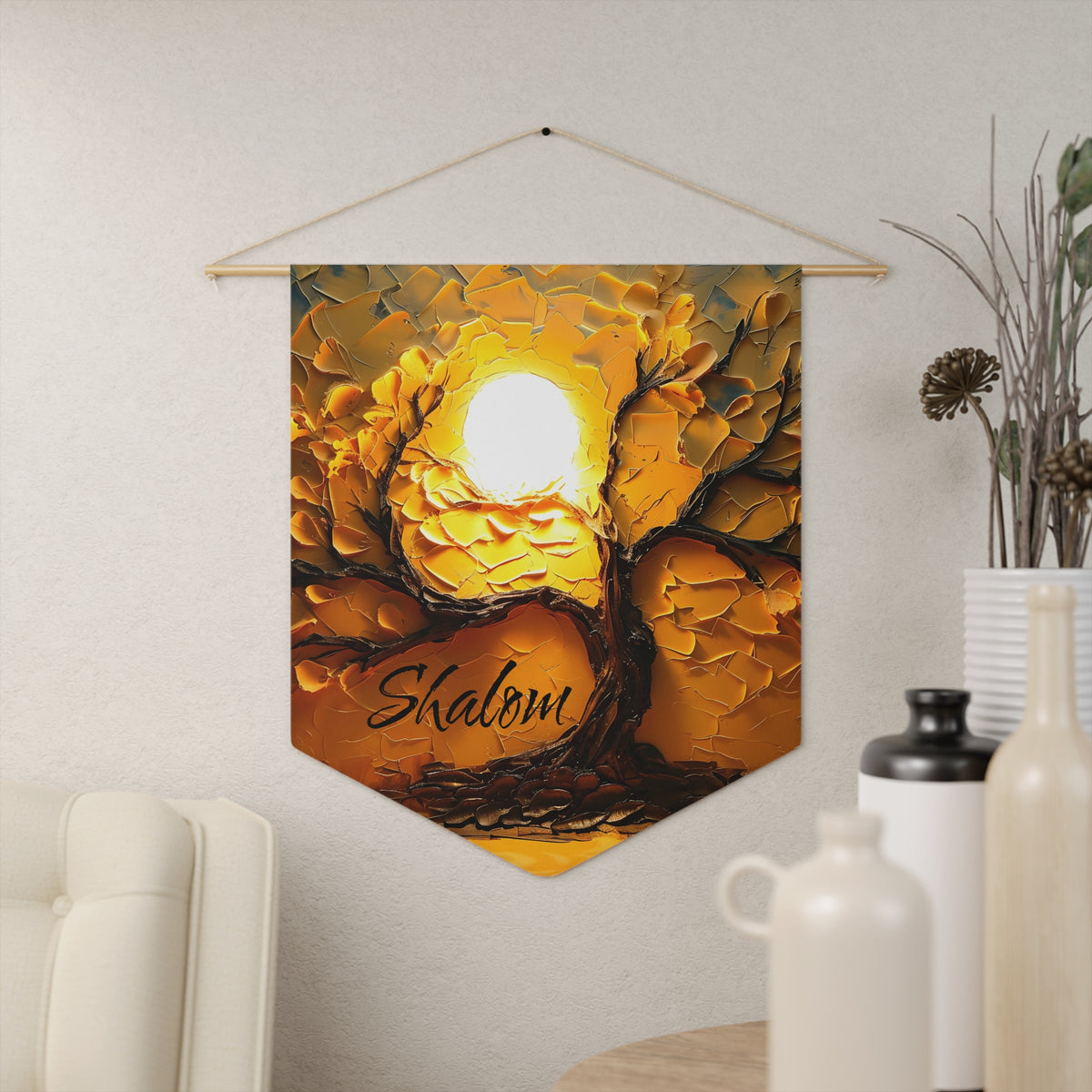 Golden textured Shalom wall pennant with a tree glowing in front of a bright sun, hanging on a cream wall beside vases
