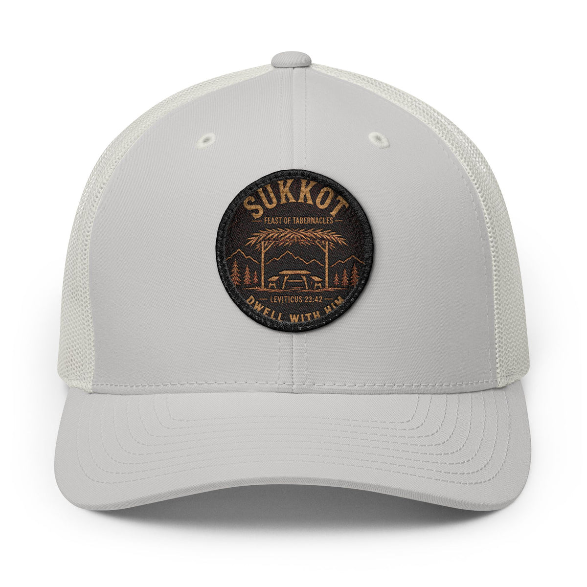 Light grey trucker cap with a round Sukkot Dwell With Him patch showing a sukkah, mountains and Leviticus 23:42, front view