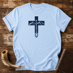 Light blue Yeshua cross t-shirt with mountains and a dove in the cross, laid flat with a shofar and Bible