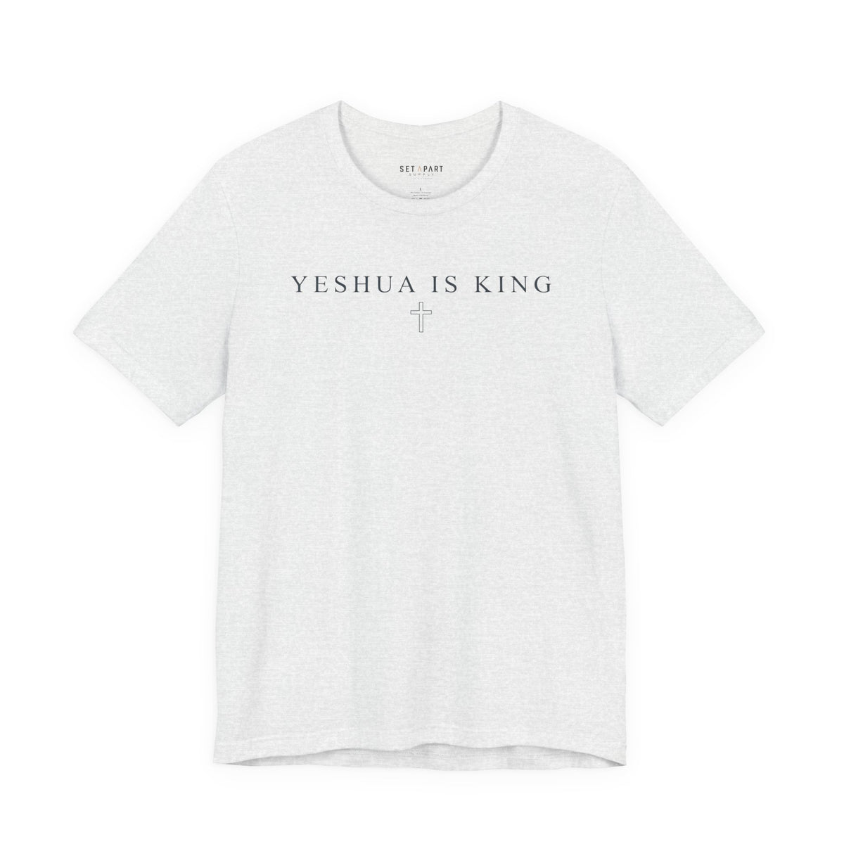 Ash gray t-shirt with small YESHUA IS KING text above a thin outlined cross, shown front on a white background