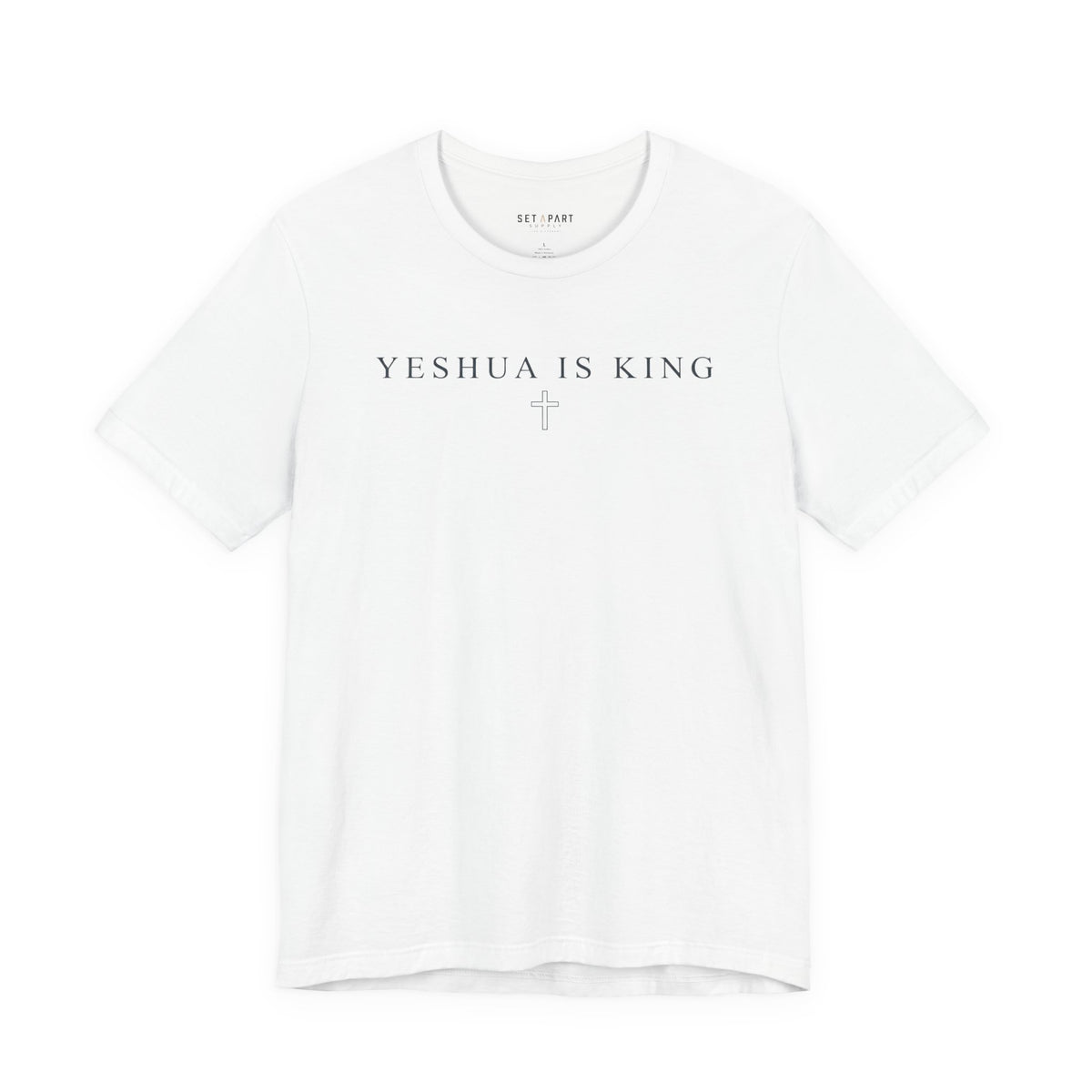 White t-shirt with small YESHUA IS KING text above a thin outlined cross, shown front on a white background